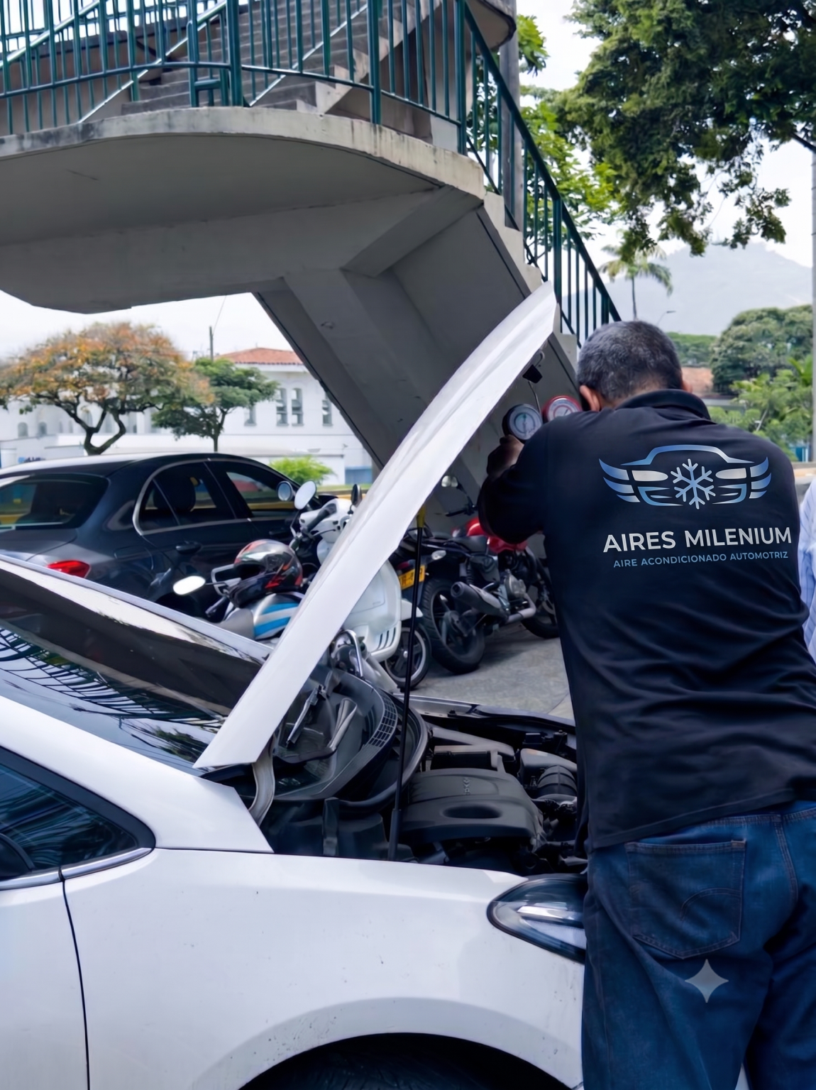 Tecnico revisando el manometro del sistema de aire acondicionado automotriz en taller moderno